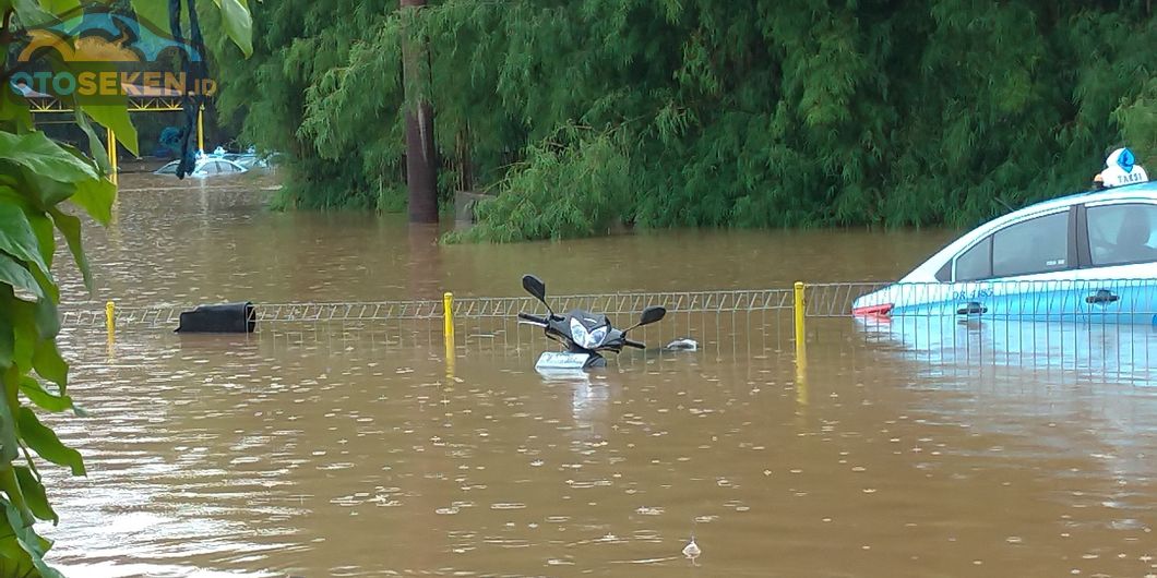 Satu unit Honda Supra X 125 terlihat terendam banjir, begitu pun dengan mobil taksi Bluebird berjeni