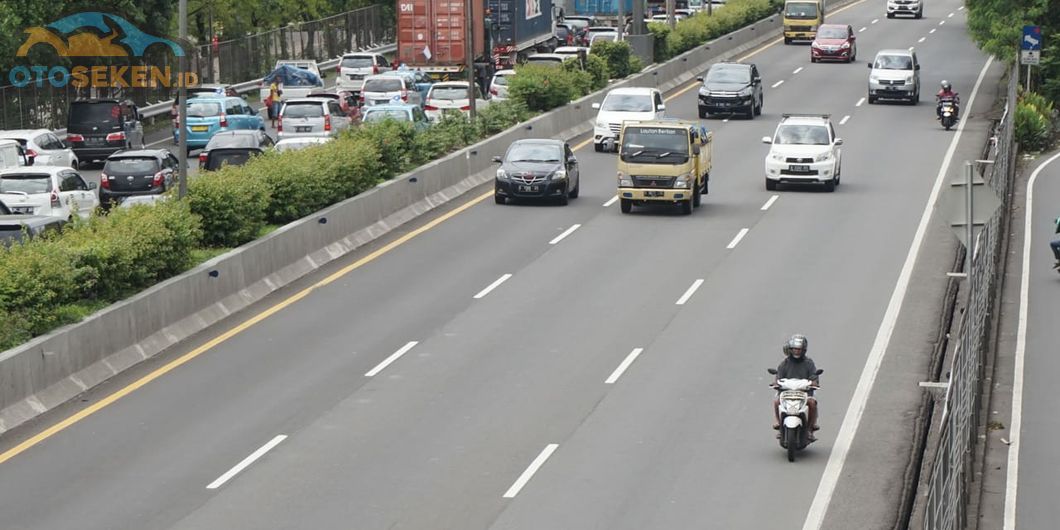 Pemotor melintasi jalan tol Jakarta - Merak akibat banjir yang menggenangi wilayah Ciledug hingga Ke