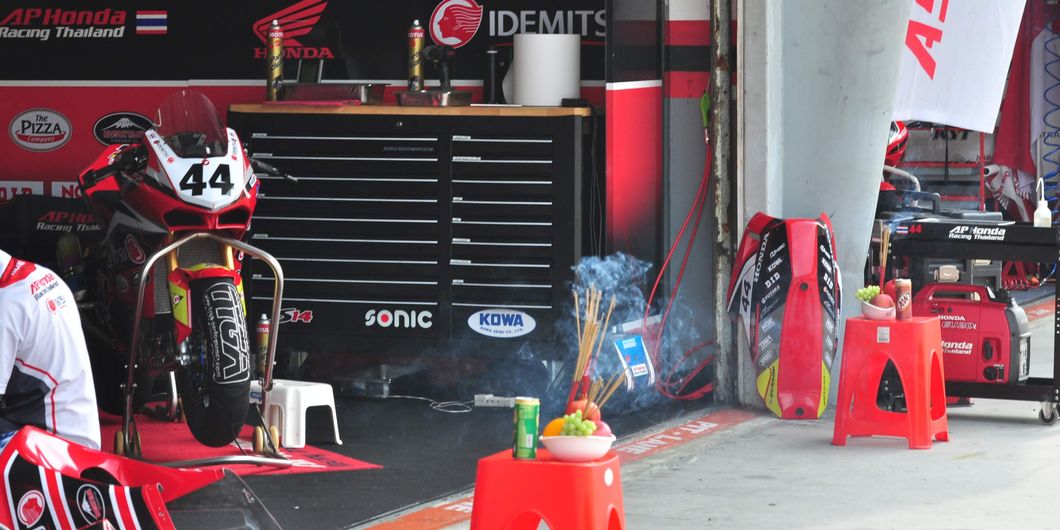 Tampak sesajen tersaji di depan paddock Tim AP Honda Thailand