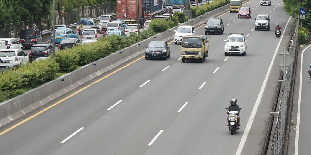 Pemotor melintasi jalan tol Jakarta - Merak akibat banjir yang menggenangi wilayah Ciledug hingga Ke