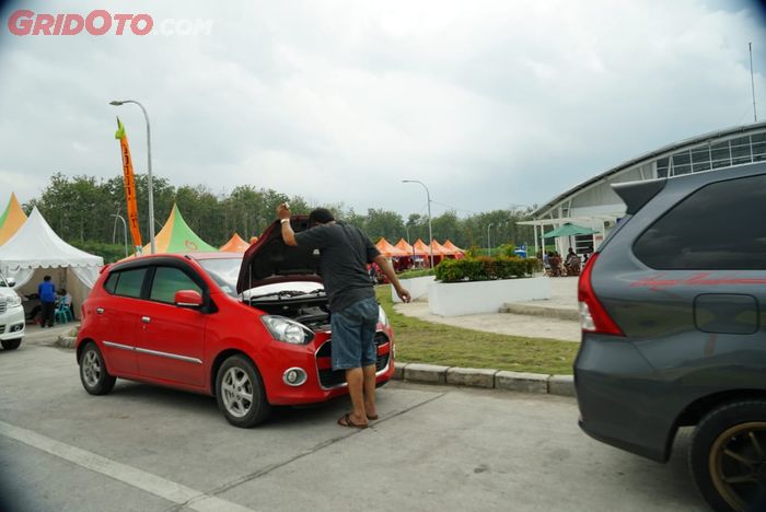 Seorang pengemudi melakukan pengecekan kondisi mobilnya di rest area Tol Trans Jawa