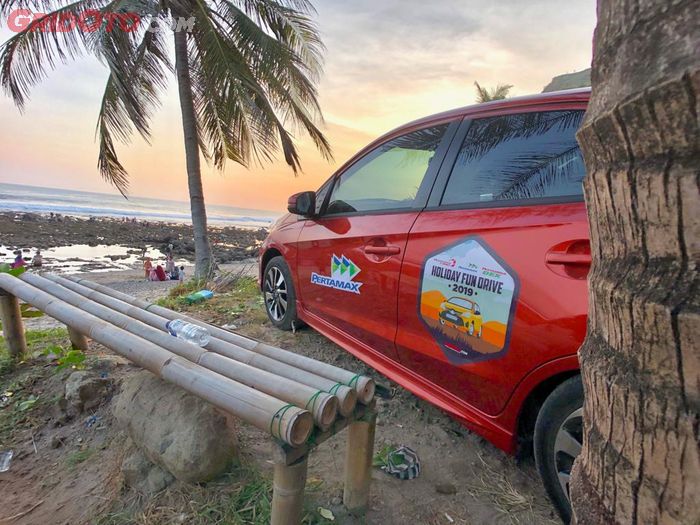 Honda Brio RS CVT bersandingan dengan view menjelang matahari terbenam di Pantai Menganti