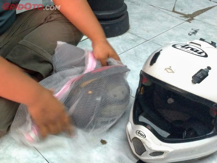 Busa helm dimasukkan dalam kantong jaring untuk dicuci