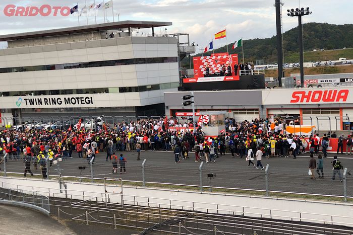 Balapan MotoGP Jepang selesai, penonton bosa ramai-ramai masuk ke sirkuit untuk memeriahkan proses pembagian trofi di podkum