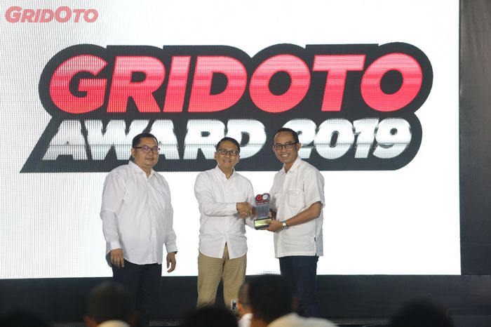 Harry Kristianto, selaku Deputy Group Director (Tengah) dan Billy Riestianto, selaku General Manager Otomotif Group (Kiri) saat memberikan penghargaan  kepada PT Astra Honda Motor (AHM) di GridOto Award 2019