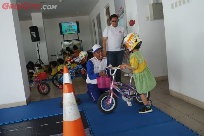 Sudah sejak dini pelajar TK ini diperkenalkan keselamatan berkendara di jalan.