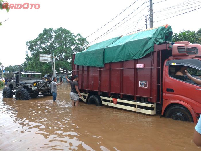 Jeep yang sama masih kuat menarik sebuat truk dari pool yang terendam banjir.