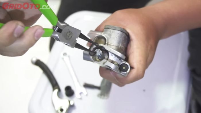 Lepas klip penutup piston master rem pakai tang jepit