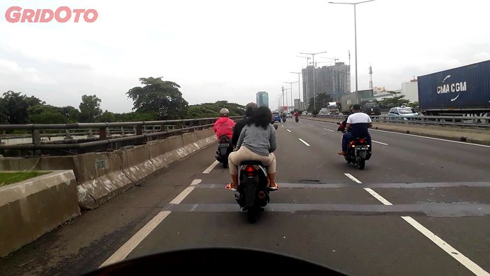 Pemotor yang tidak menggunakan helm saat melewati jalan tol