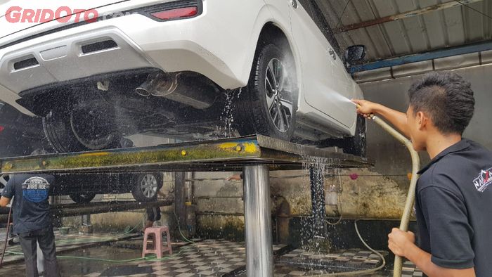 Cuci mobil hidraulis lebih aman yang menumpu keempat roda.
