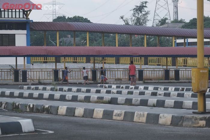 Anak-anak tampak bermain di lahan parkir bus di Terminal Jatijajar, Kota Depok, Jawa Barat, yang kosong.