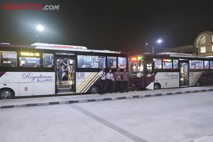Para kru dan dua unit bus Trans Royal pengangkut tenaga medis yang digunakan untuk keberangkatan malam dari terminal Depok.