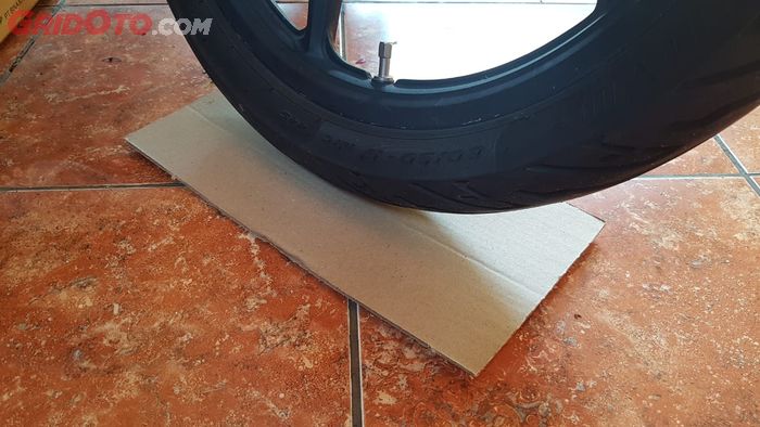 Ban motor diberi alas kardus supaya tidak bersentuhan langsung dengan permukaan lantai