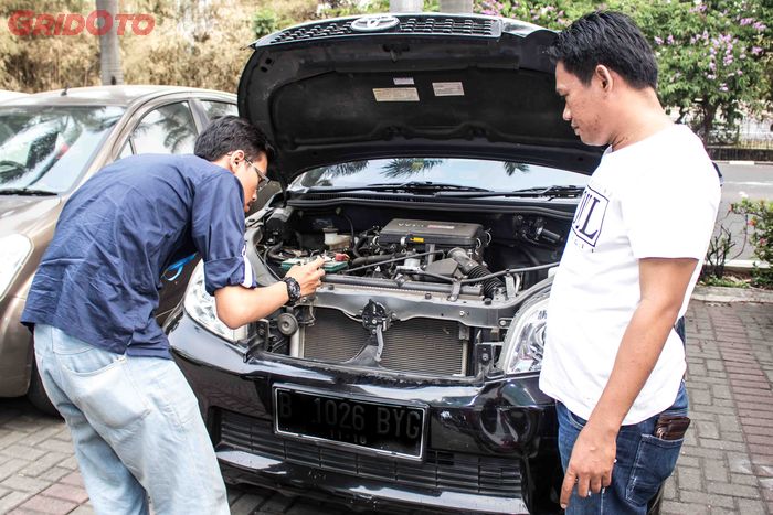 Ilustrasi pengecekan kondisi mobil bekas oleh pembeli