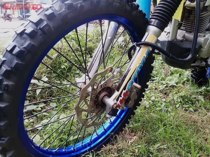 Pelek asli  Kawasaki KLX ini diganti dengan Scarlet Kenda biru ukuran depan 21 dan belakang 18 inci
