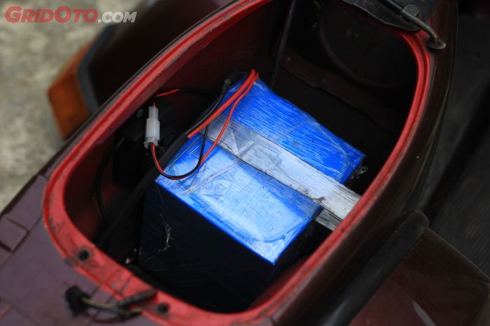 Baterai dengan spesifikasi 1,2 kWh 60 volt 20 ampere diletakkan di bawah jok, menggantikan tangki bensin