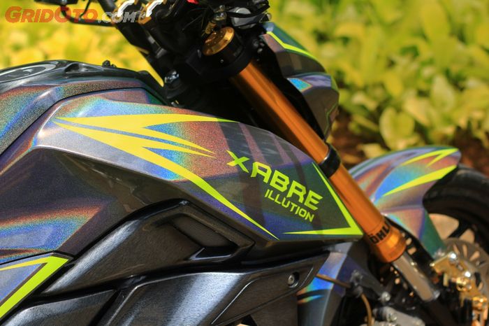 Seluruh bodi dibalut warna hologram dikombinasi striping minimalis