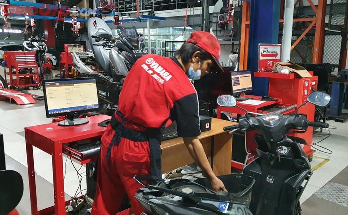 Ilustrasi servis motor di bengkel resmi Yamaha dengan alat diagnostic tools