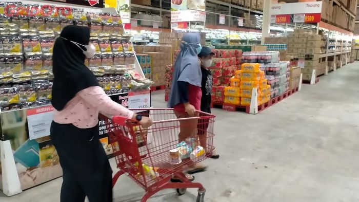 Kegiatan berbelanja di supermarket bersama keluarga.