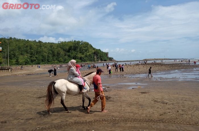 Seorang pengunjung naik kuda di Pantai Ayah