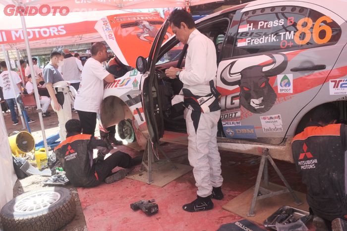 Mekanik tim Banteng Motorsport melakukan perawatan pada Mitsubishi Evo X.