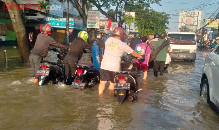 Beberapa pengendara motor matic yang terobos banjir di Jl. K.H. Hasyim Ashari, Ciledug, Tangerang