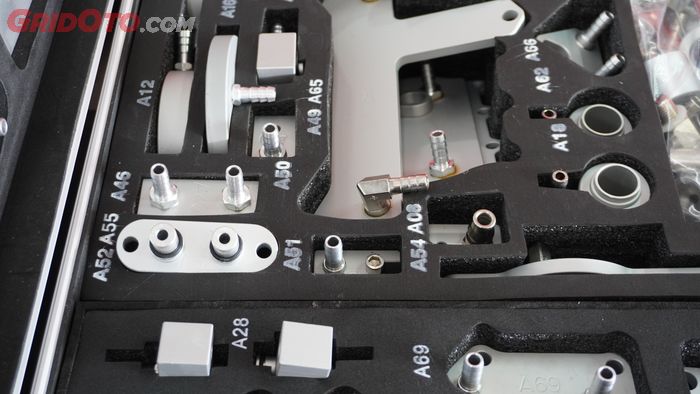 Dua jalur pipa pada adaptor yang dipasang di blok cooling system girboks transmisi CVT mobil.