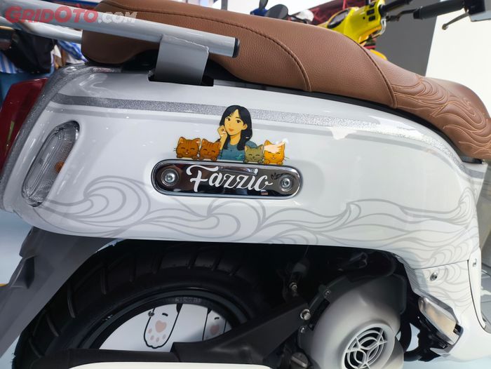 Bodi warna putih dengan aksen ombak dan grafis Zee bersama kucing kesayangannya