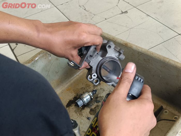 Proses membersihkan throttle body