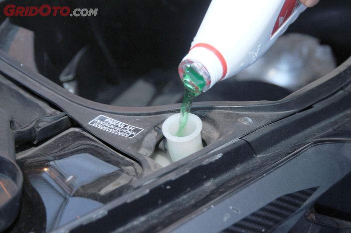 Tambah air radiator lewat lubang pengisian yang ada di tabung reservoir