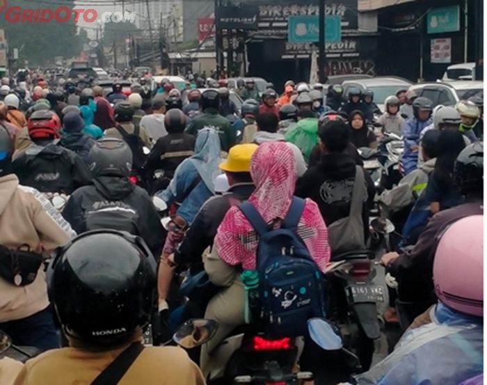 Jalan macet menghindari jalan berlubang