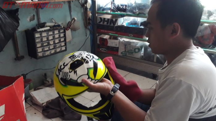 Rifa, Pegawai Bengkel Helm sedang meng-coating helm AGV milik pelanggan.