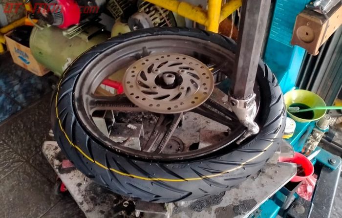 Proses penggantian ban tubeless motor matic dengan menggunkan alat.