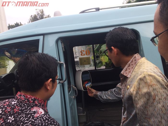 Wagub DKI Jakarta Sandiaga Uno mengetapkan kartu Ok Otrip di mesin tap angkot