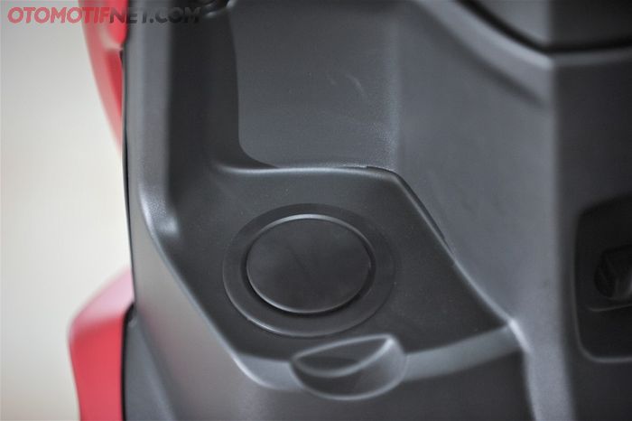 Mulut tangki bensin ada di sisi kiri, bukanya melalui kunci kontak di kanan yang di atasnya ada power outlet