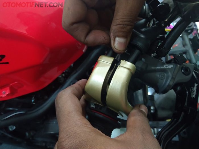 Sejajarkan kabelnya dan pasang cover gas sekaligus sebagai pengikat ke setang motor