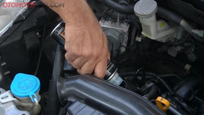 Ilustrasi lagi menuang engine flush ke dalam mesin.