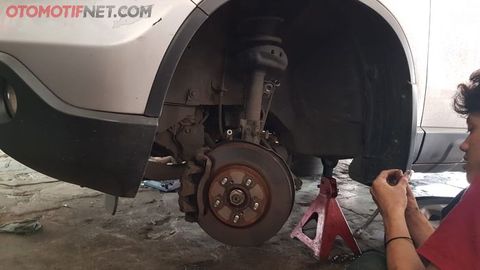 Ilustrasi sokbreker mobil yang diperbaiki di bengkel