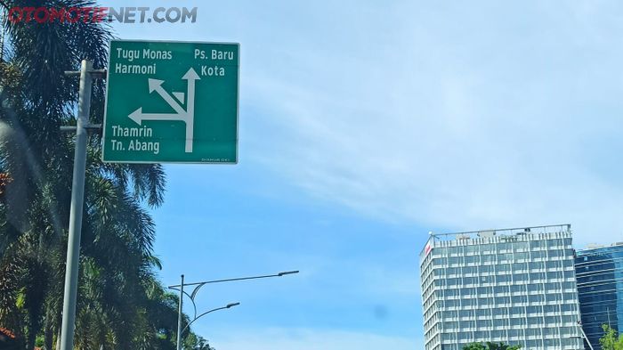 Rambu petunjuk memberi informasi arah berwarna dasar hijau tulisan putih