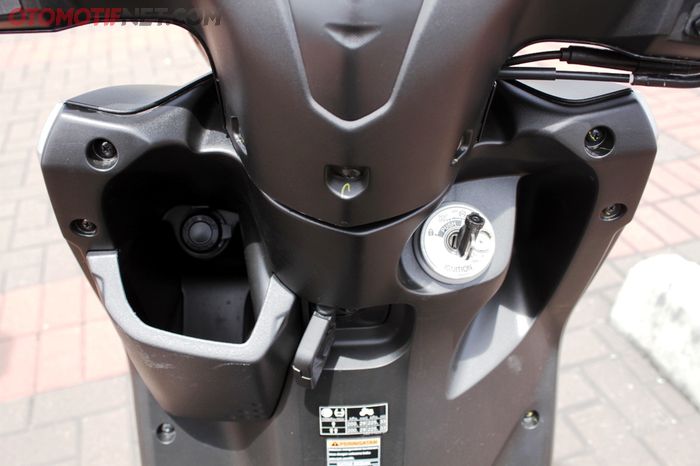 Tersedia electric power socket di laci sebelah kiri Yamaha Gear 125, kontaknya dilengkapi pengaman magnet