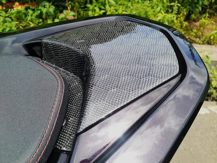 Warna Burning Red kece dipadu aksen karbon kevlar pada tutup behel belakang