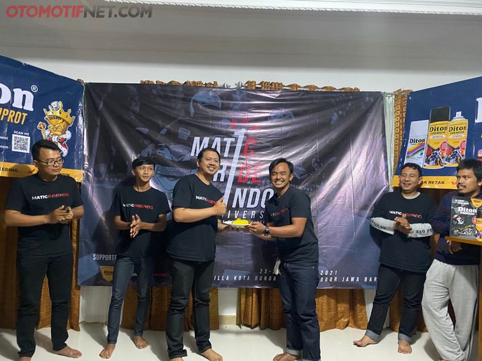 Andhika Hadi Saputra (kiri) selaku founder MRI menerima potongan nasi tumpeng dari Dede Kurniawan (kanan) selaku ketua umum baru MaticRideIndo