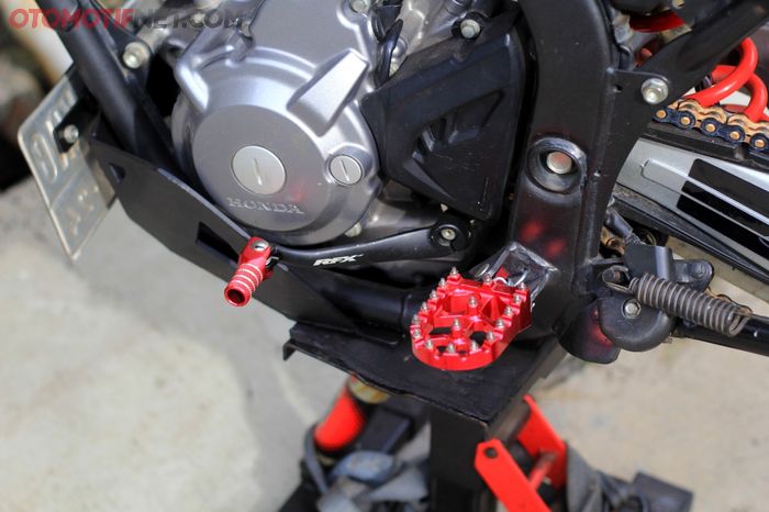 Aksesori seperti pedal persneling dan footpeg dari RFX, berbahan aluminium dengan anodize merah senada bodi