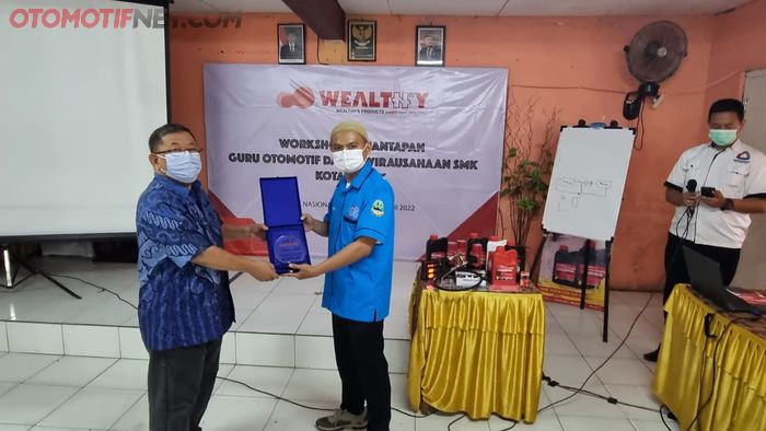 Pemberian plakat kepada perwakilan guru SMK Nasional Kota Depok