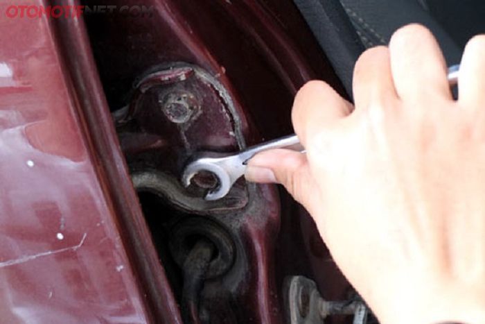 memperbaiki engsel pintu mobil