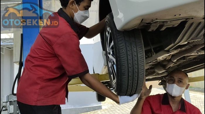 Untuk pengecekan ball joint, goyangkan roda ke atas dan ke bawah