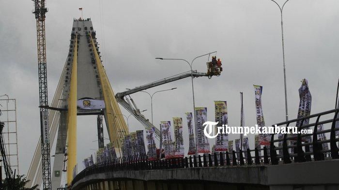 Proses pemasangan lampu di Jembatan Siak IV