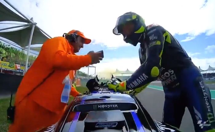 Diminta untuk pegangi, marshal ini justru spontan langsung ingin menunggangi motor milik Valentino Rossi