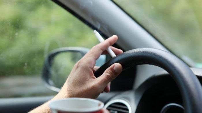 Foto ilustrasi merokok sambil menyetir mobil