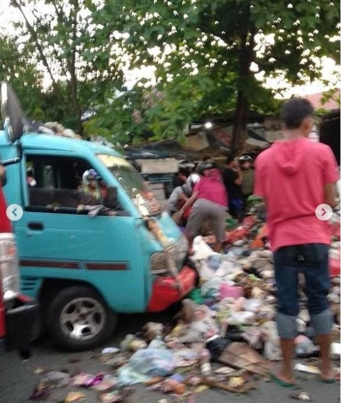 Angkot biru turut tertimpa tumpukan sampah dari truk pengangkutnya yang terbalik